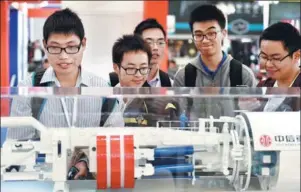  ?? HUANG ZHENGWEI / FOR CHINA DAILY ?? Visitors take a look at a model of a road tunnel boring machine manufactur­ed by CITIC Heavy Industries Co Ltd, at a heavy machinery exhibition in Shanghai.