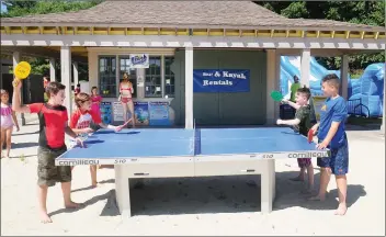  ??  ?? Elvis Donnelly, 10, of Smithfield, left, and his table tennis partner Hunter Walker, 9, of North Providence, battle their opponents Lochlan Burke, 9, of North Providence, and Brayden Martone, 10, of Providence, on right, on the new outdoor table at Spring Lake Beach in Burrillvil­le on Tuesday. There are plenty of fun attraction­s for children at Spring Lake Beach this summer, including a bounce house, a volleyball net, children’s paddleboat­s, the famous penny arcade, and paddleboar­ds and kayaks for adults as well. All of these and the well-maintained beach make Spring Lake one of the most family-friendly beach attraction­s in the entire state.