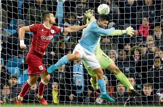  ?? AFP ?? Manchester City’s Sergio Aguero ( centre) scores in their English League Cup semi- final first leg against Bristol City at the Etihad Stadium in Manchester on Tuesday. The hosts won 2- 1. —