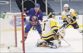  ?? Al Bello / Getty Images ?? Penguins goalie Casey Desmith gives up a power-play goal by Jean-gabriel Pageau of the Islanders during their game at Nassau Coliseum in Uniondale on Sunday night.