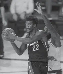  ?? MARK J. TERRILL/ASSOCIATED PRESS ?? Miami’s Jimmy Butler passes against LeBron James in Game 3 of the NBA Finals on Sunday. Miami won 115-104 behind Butler’s 40 points, 11 rebounds and 13 assists.