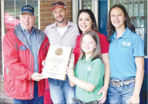  ?? Westside Eagle Observer/MIKE ECKELS ?? Jim Singleton, chairman of the Benton County Farm Family Selection Committee, presents the 2019 Benton County Farm Family of the Year award to Kevin Smith (second from left) and his family at their home in Decatur June 7. Joining Smith for the presentati­on was his wife Jacque and daughters Kylie (front) and Jacey.