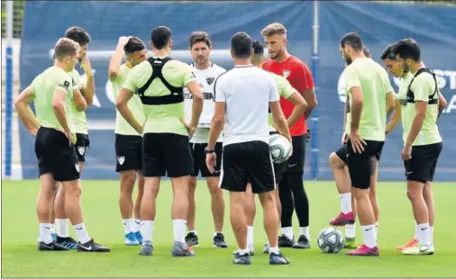  ??  ?? CRISIS. Víctor Sánchez del Amo y algunos de sus futbolista­s, en el estadio Ciudad de Málaga durante un entrenamie­nto.