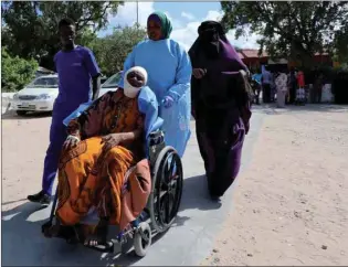  ??  ?? A paramedic and civilians at Madina hospital assist an injured woman at Hawa Abdi village, northwest of Mogadishu.