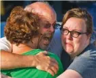  ?? AP PHOTO/BARRY GUTIERREZ ?? Tom Sullivan, center, embraces family members July 20, 2012, after losing his son, Alex, in a movie theater shooting in Aurora, Colo.