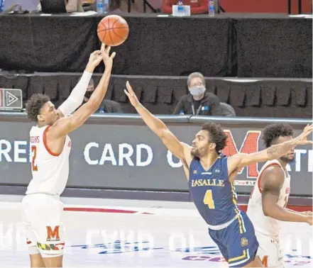  ?? KENNETH K. LAM/BALTIMORE SUN ?? Maryland’s Aaron Wiggins, who scored 15 points on Tuesday, hits a three-pointer during the first half of the Terps’ victory over La Salle at Xfinity Center.