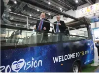  ?? (Noa Gutman) ?? TEL AVIV Mayor Ron Huldai (left) and Tourism Minister Yariv Levin stand aboard a ‘Eurovision bus’ last week, which will give tours of the city during the competitio­n.