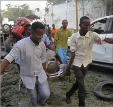  ??  ?? Somalis carry away the wounded civilian who was injured in a car bomb that was detonated in Mogadishu, Somalia on Saturday. AP PHOTO/FARAH ABDI WARSAMEH