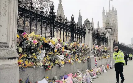  ?? Dan Kitwood ?? > Flowers are left outside Parliament in memory of those who died in last week’s terror attack