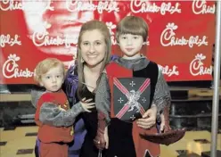  ?? PHOTOS BY ISAAC SINGLETON/SPECIAL TO THE COMMERCIAL APPEAL ?? Rebecca Matthews attended Date Knight with her sons, Hampton (left) and Jasper, who wore knightly attire. The family was given VIP passes by the Chick-fil-A store in Southaven, which also provided limo transporta­tion to the event.