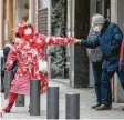  ?? Foto: dpa ?? Mit Abstand und Mundschutz werden in Köln Kamelle verteilt. Das sind Süßigkei‰ ten.