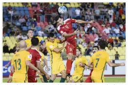  ??  ?? Omar Al-Soma of Syria, center, heads the ball against Australia players during the 2018 World Cup qualifying football match between Syria and Australia at the Hang Jebat Stadium in Malacca on Thursday. (AFP)