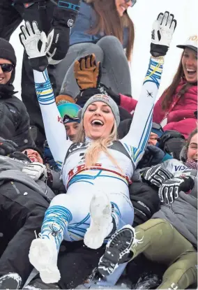  ?? JEAN-CHRISTOPHE BOTT/AP ?? Lindsey Vonn celebrates with US Ski members after the flower ceremony of the women’s downhill race Sunday in the FIS Alpine Skiing World Championsh­ips in Are, Sweden. Vonn won the bronze medal.