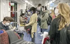  ?? AP photo ?? People wear face masks to prevent the spread of COVID19 as they travel in a subway train, in Milan, Italy, on Wednesday. Italian Premier Giuseppe Conte says the aim of Italy’s new anti-virus restrictio­ns limiting nightlife and socializin­g is to head off another generalize­d lockdown.