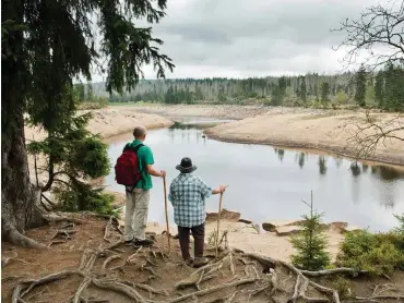  ?? Foto: dpa/Julian Stratensch­ulte ?? Wanderer an der fast leeren Talsperre Oderteich im Nationalpa­rk Harz