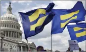  ?? JACQUELYN MARTIN — THE ASSOCIATED PRESS FILE ?? People with the Human Rights Campaign hold up “equality flags” during an event on Capitol Hill in Washington in support of transgende­r members of the military.