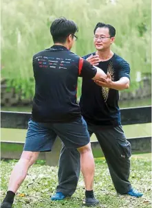  ??  ?? Tan (right) demonstrat­ing combat techniques with one of his students.