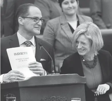  ?? IAN KUCERAK / POSTMEDIA NEWS ?? Alberta Finance Minister Joe Ceci and Premier Rachel Notley unveil the provincial budget on Thursday. Notley said she knows Albertans are worried about the growing size of the debt, but it is “absolutely manageable.”