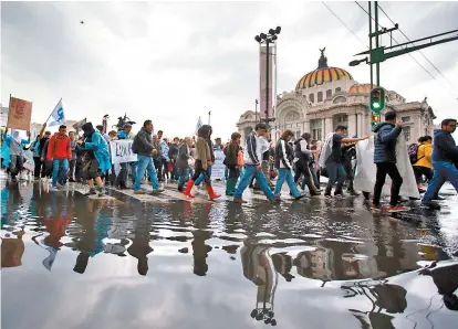  ??  ?? A cuatro años de la noche de Iguala, alrededor de 15 mil marcharon al Zócalo a pesar de la lluvia.