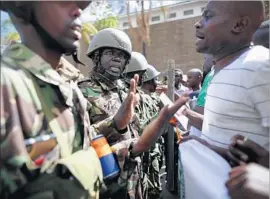  ??  ?? ODINGA’S SUPPORTERS argue with police as they are stopped from approachin­g the Supreme Court building. The court ordered a new election for Oct. 17.