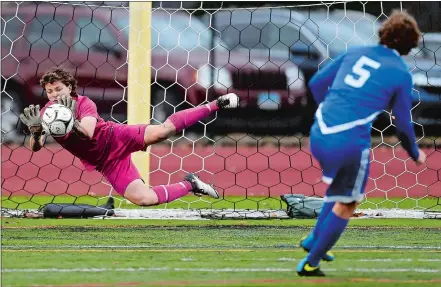  ?? SEAN D. ELLIOT/THE DAY ?? East Lyme goalie Sean Heaney makes a diving save off a penalty kick attempt by Bacon Academy’s Noah O’Connor (5) during Thursday’s Eastern Connecticu­t Conference tournament quarterfin­al game at East Lyme. After playing to a 1-1 tie over 100 minutes,...