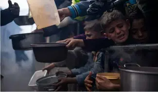  ?? ?? Palestinia­ns line up for a free meal in Rafah, Gaza Strip, Friday, Feb. 16, 2024.