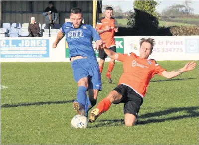  ??  ?? ● Kevin Lloyd (blue) grabbed a hat-trick for Llangefni Town against Penycae