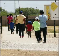  ?? ERIC GAY — THE ASSOCIATED PRESS FILE ?? In this Aug. 23, 2019file photo, immigrants seeking asylum hold hands as they leave a cafeteria at the ICE South Texas Family Residentia­l Center in Dilley, Texas.