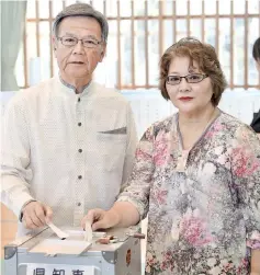  ??  ?? Takeshi Onaga (left), former mayor of Okinawa’s capital city Naha, and his wife Mikiko cast their ballots for the Okinawa gubernator­ial election at a polling station in Naha, Okinawa prefecture. — AFP photo