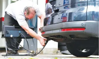  ??  ?? A MOTOR MECHANIC measures exhaust emissions in a diesel-engined car in Eichenau, Germany July 28.