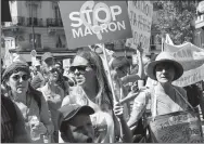  ?? FRANCOIS MORI / ASSOCIATED PRESS ?? Anti-Macron protesters rally in Paris on Saturday, under the close
watch of French police.