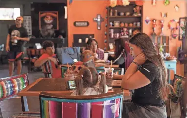  ?? PHOTOS BY ANTRANIK TAVITIAN/THE REPUBLIC ?? Yanel Meza, right, works on her computer while dining at Tres Leches Cafe in October in Phoenix.