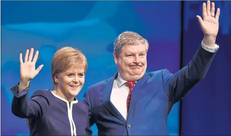  ??  ?? UNITED FRONT: First Minister Nicola Sturgeon and her deputy Angus Robertson acknowledg­e the applause at the SNP’s conference in Aberdeen. Picture: Getty Images