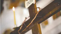  ?? ALKIS KONSTANTIN­IDIS / REUTERS ?? A crown of thorns is placed on a crucifix during the procession of Jesus Christ’s Deposition from the Cross.