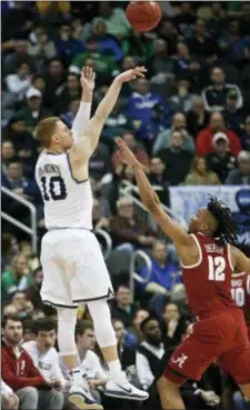  ?? KEITH SRAKOCIC — THE ASSOCIATED PRESS ?? Villanova’s Donte DiVincenzo, left, hits a three over Alabama’s Jermaine Samuels during the NCAA Tournament second-round game in Pittsburgh.