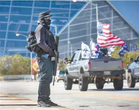  ?? MARIE-FRANCE COALLIER LE DEVOIR ?? Vendredi, pour une troisième journée consécutiv­e, une cinquantai­ne de partisans de Trump étaient réunis devant le State Farm Arena, à Atlanta, pour réclamer que les bulletins « illégaux » soient écartés. Parmi eux, Quinton Davis, muni d’un AR-15.