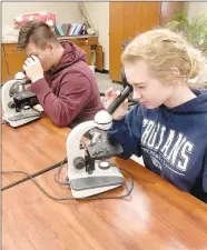  ?? SUBMITTED PHOTO ?? Kris Martinez (left) and Carol Burnett, members of Lincoln High FFA Chapter, receive hands-on experience while completing a swine sperm mobilizati­on lab in their vet science class.