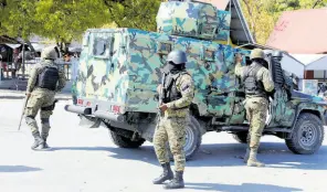  ?? AP ?? Members of the General Security Unit of the National Palace, set up a security perimeter around one of the three downtown stations after police fought off an attack by gangs the day before, in Port-au-Prince, Haiti, Saturday, March 9.