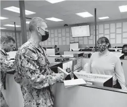  ?? DAVE RESS/STAFF ?? Fleet Master Chief Wes Koshoffer visits MyNavy Career Center staffer Marcie Farley. The center is utilizing new software to more effectivel­y handle sailors’ inquiries on topics such as their finances.