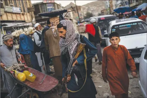  ?? (AP/Bernat Armangue) ?? Taliban fighters patrol a market Sept. 14 in Kabul’s Old City in Afghanista­n.
