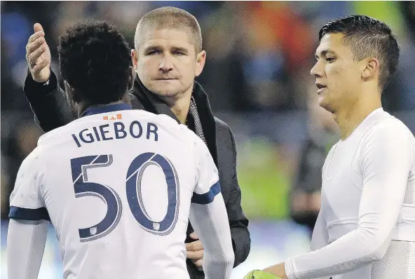  ?? — THE ASSOCIATED PRESS ?? Whitecaps head coach Carl Robinson reaches to give midfielder Nosa Igiebor a pat as striker Fredy Montero, right, watches after the Caps were eliminated from the MLS playoffs by the Seattle Sounders Thursday. Robinson says the team needs better players.