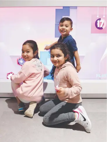  ?? Pictures: BRENDAN RADKE ?? HAPPY: Madison Dermatossi­an, 7, Lucas Dermatossi­an, 3, and Mitani Ghattas, 7, play an interactiv­e game in the children’s zone at the new Cairns Airport domestic terminal.