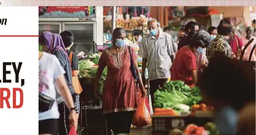  ?? BERNAMA PIC ?? People wearing face masks and following the standard operating procedure as they shop at the Seremban wet market yesterday.