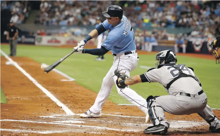  ?? — GETTY IMAGES ?? Logan Morrison of the Tampa Bay Rays singles in front of Yankees catcher Gary Sanchez to drive in two runs during the first inning on Sunday at Tropicana Field.