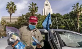  ?? Photograph: Damian Dovarganes/ AP ?? Jose Luis Guevara shows personal protective equipment he provides freely to ride-sharing customers for their safety, outside Los Angeles City Hall.