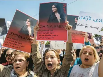  ?? SAFIN HAMED/GETTY-AFP ?? Women hold up images of Mahsa Amini, who died in Iranian custody, during a demonstrat­ion Saturday in Arbil, the capital of Iraq’s autonomous Kurdistan region.