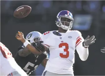  ?? Thearon W. Henderson / Getty Images ?? Giants quarterbac­k Geno Smith is stripped of the ball by Raiders linebacker Bruce Irvin. Smith was sacked three times and fumbled twice in the two-win Giants’ loss at the Coliseum.