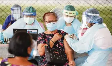  ?? EPA PIC ?? Health officials administer­ing a Covid-19 vaccine to a woman at a non-hospital vaccinatio­n facility in Bangkok on Friday.