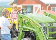  ??  ?? Fair visitors check out some of the tractors.