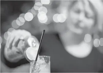  ?? THE CANADIAN PRESS ?? Toronto’s Rachel Conduit makes a drink in a glass containing a biodegrada­ble straw at her Farside bar.